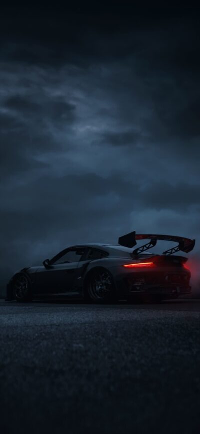 Sleek sports car with rear wing under a cloudy night sky, glowing rear lights; black, grey, red | 4K Wallpaper, for Mobile