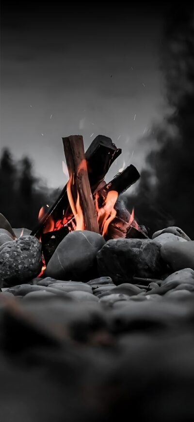 Campfire with glowing flames, stones, dark forest backdrop; warm, rustic atmosphere | Orange, Gray, Black | 4K Wallpaper for Mobile