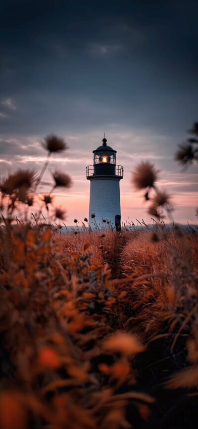 Serene lighthouse at twilight with tall grass and pastel sunset sky | 4K Wallpaper for Mobile | Dark, Orange, Blue hues