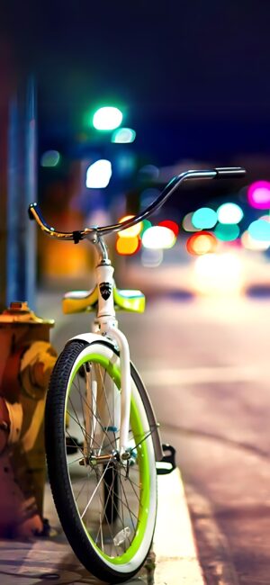 Bicycle with green accents by fire hydrant, colorful bokeh city background, urban night vibe | 4K Wallpaper for Mobile