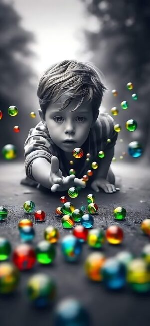 Young child reaching for colorful marbles on the ground; vibrant green, red, yellow, and blue hues | 4K Wallpaper for Mobile