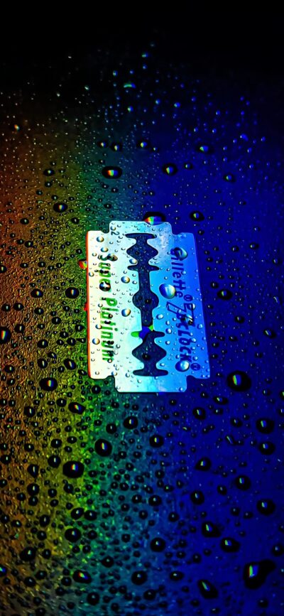 Gillette razor on a vibrant, colorful background with water droplets and a rainbow effect | 4K Wallpaper for Mobile