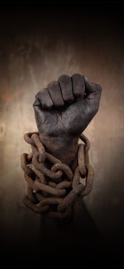 Clenched fist in rusty chains symbolizing strength and resilience against dark background | Brown & Black | 4K Wallpaper for Mobile