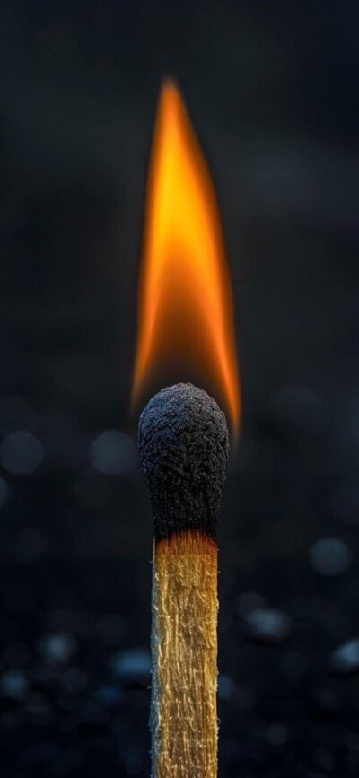 Lit matchstick against a dark background; vibrant flame with orange and yellow glow. | 4K Wallpaper for Mobile