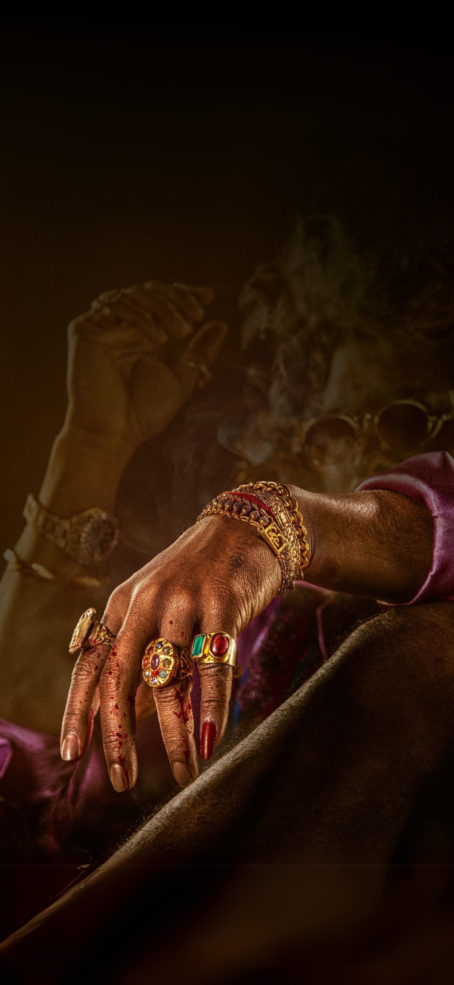 Hand with ornate rings and bracelets in smoky setting, blood adds drama. Brown, gold, red colors. | 4K Wallpaper for Mobile