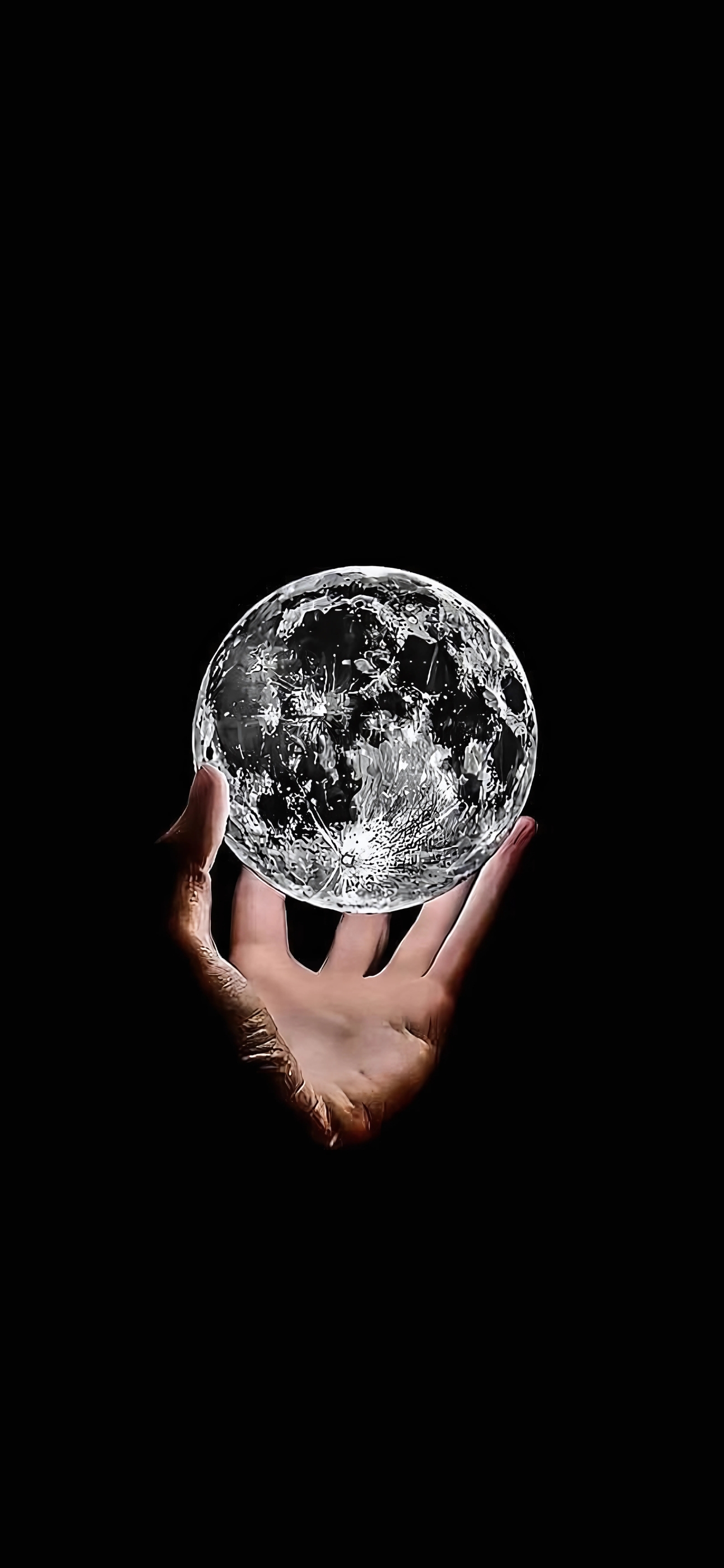 Hand holding a luminous globe with lunar textures on black background | Space & Fantasy Theme | Black & White | 4K Wallpaper for Mobile