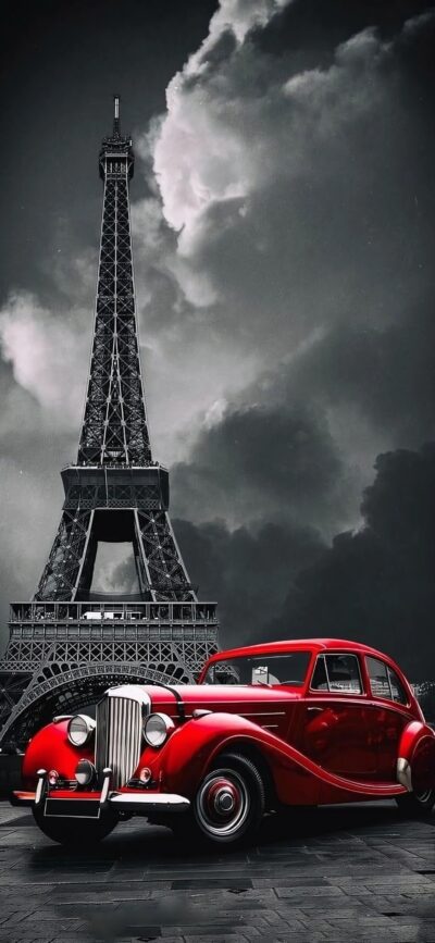 Vintage red car with Eiffel Tower under dramatic sky | Black & white contrast, vibrant red | Classic & timeless | 4K Wallpaper for Mobile