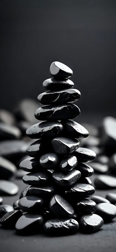 Glossy black pebbles on a dark backdrop, evoking tranquility and balance. Minimalist design. | 4K Wallpaper for Mobile