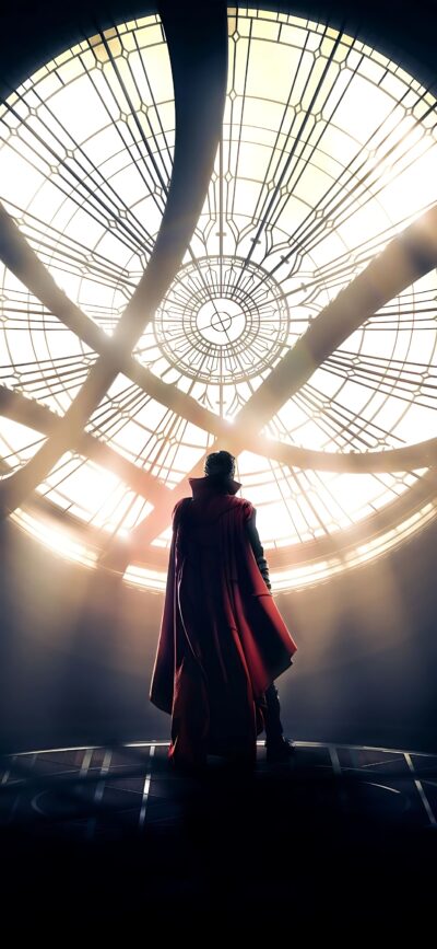 Character in red cloak by intricate window, conveying magic and mystery vibes, associated with Doctor Strange | 4K Wallpaper for Mobile