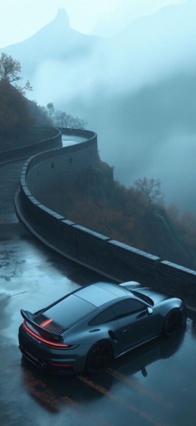 Sleek sports car on a misty, winding mountain road, evoking adventure and mystery. Blue & gray tones | 4K Wallpaper for Mobile