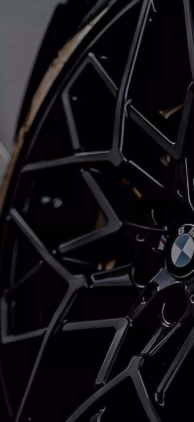 Close-up of BMW wheel with sleek black alloy spokes and iconic logo, perfect for car enthusiasts. | 4K Wallpaper for Mobile