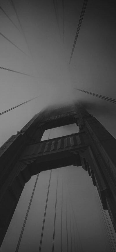 Monochrome bridge tower in mist, dramatic cables stretching upwards. Moody, timeless architecture. | 4K Wallpaper for Mobile