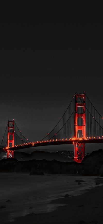 Golden Gate Bridge at night with vibrant red against a monochrome backdrop and city lights | 4K Wallpaper for Mobile