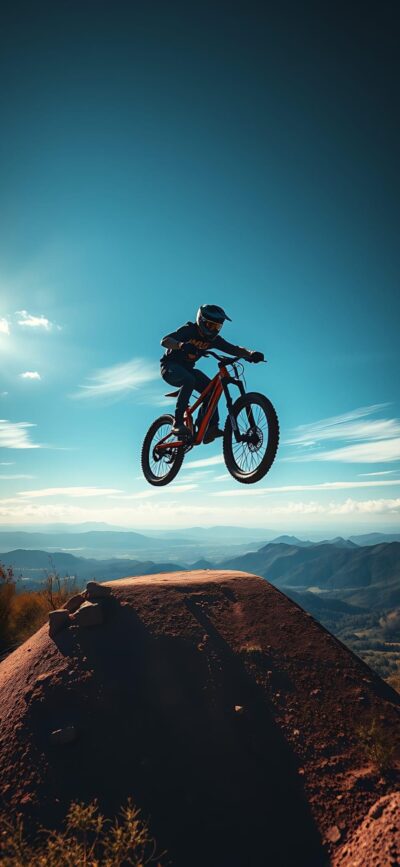 Mountain biker jumping on dirt trail, blue sky, mountains | Adventure, Sports | 4K Wallpaper for Mobile