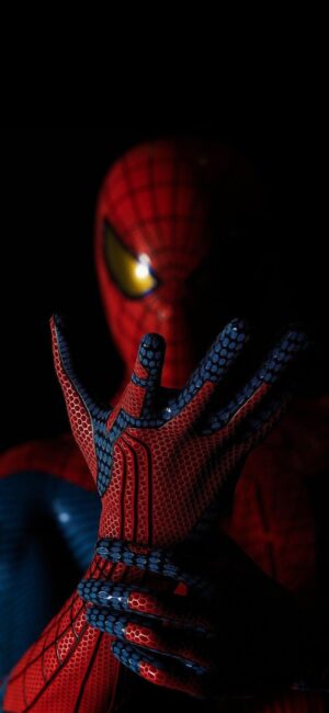 Spiderman in textured red and blue suit with web-shooting gesture on dark background | 4K Wallpaper for Mobile