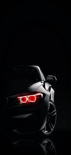 BMW sports car with red headlights against dark background, showcasing sleek design and dynamic lighting | 4K Wallpaper for Mobile