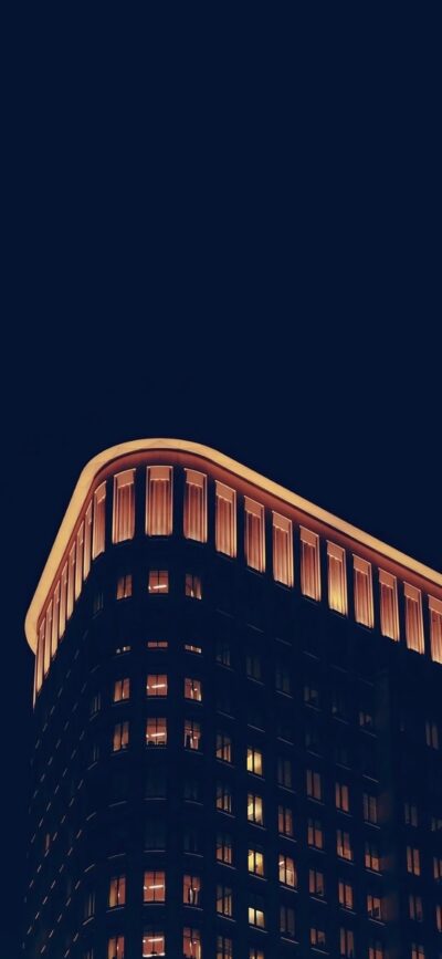 Modern architectural building with illuminated edges, sleek corners against a dark night sky | Black, Gold, Brown | 4K Wallpaper for Mobile