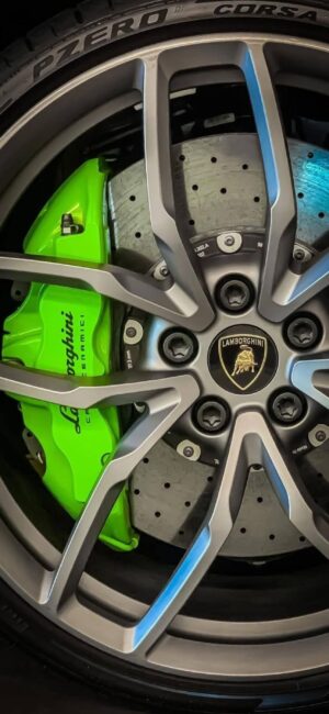 Close-up of Lamborghini green brake caliper, "P ZERO" and "CORSA" on metallic wheel | 4K Wallpaper for Mobile | Black, Green, Silver