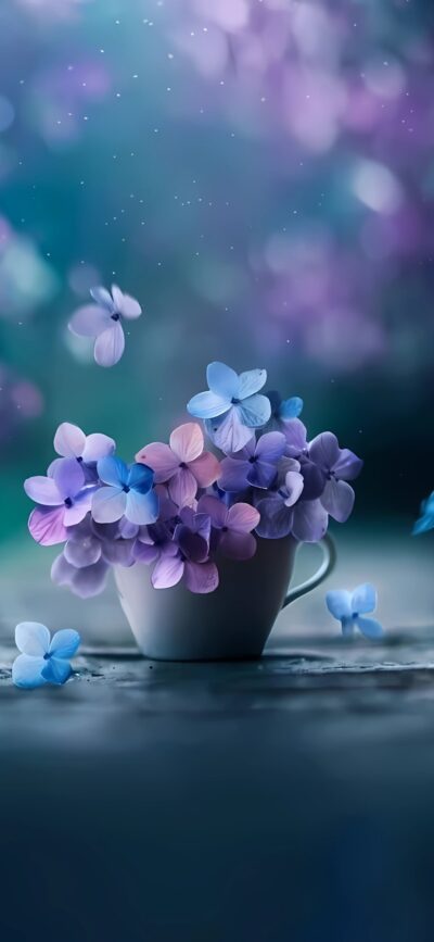 A dreamy 4K wallpaper for mobile featuring soft blue and purple flowers in a teacup with a blurred, ethereal background.