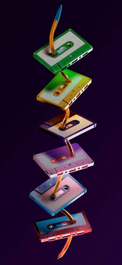 Colorful cassette tapes pierced by pencils on dark background | 4K Wallpaper for Mobile