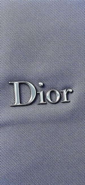 Dior logo on a textured grey background, reflecting luxury and elegance | 4K Wallpaper for Mobile