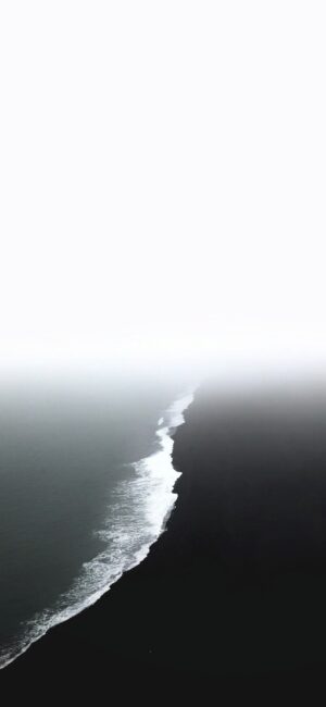 Serene minimalist seascape with ocean waves, misty shoreline, and contrasting skies | Black, white, grey | 4K Wallpaper for Mobile