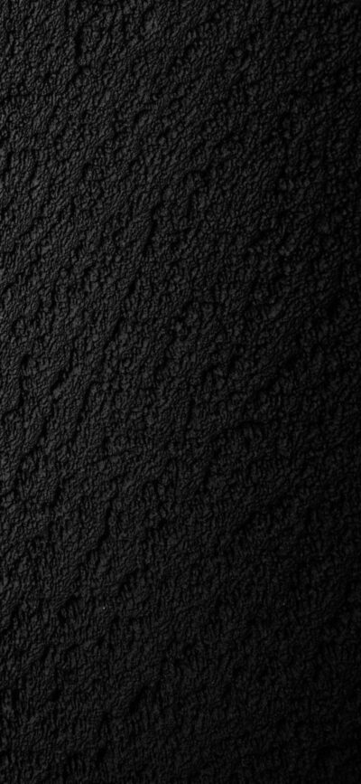 Textured black surface with a rough, granular pattern, creating a dark and sophisticated look | 4K Wallpaper for Mobile