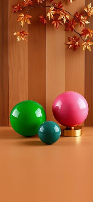 Minimalist 4K wallpaper for mobile featuring vibrant spheres in green, pink, and blue on wood, with autumn leaves above.