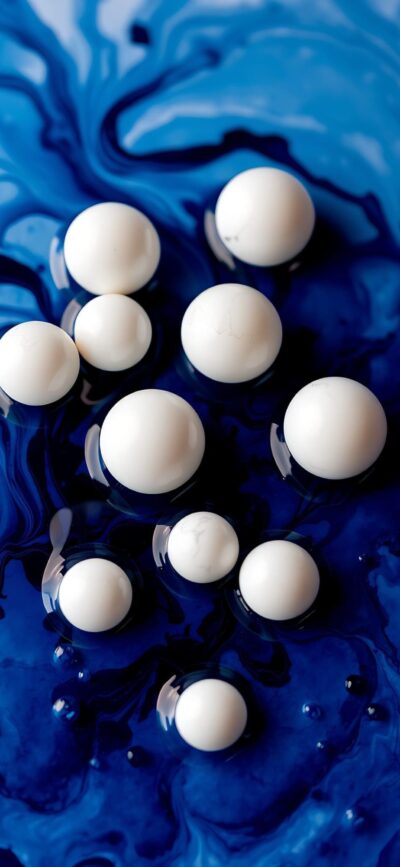 White spheres on swirling blue liquid background, creating striking abstract design. | 4K Wallpaper for Mobile