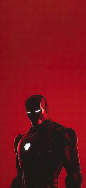 Iron Man in a striking pose, glowing chest piece, bold red background | 4K Wallpaper for Mobile